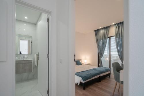 1 Schlafzimmer mit einem Bett und einem Bad in der Unterkunft HM - HouseMirage in Paço de Arcos