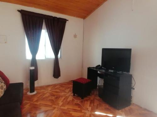 ein Wohnzimmer mit einem TV und einem Fenster in der Unterkunft Alojamiento Monik in Ríohacha