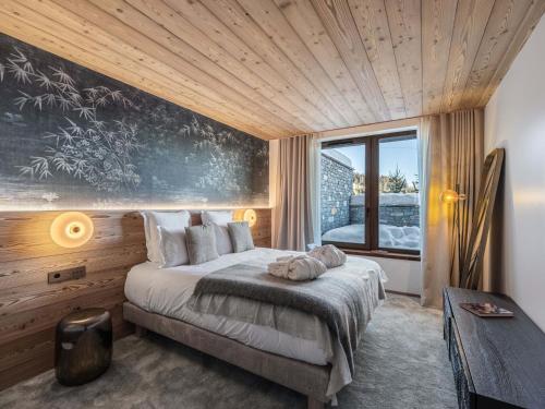 une chambre avec un lit et une grande fenêtre dans l'établissement Appartement Neuf Ski-in/Ski-out avec Piscine, SPA et Cheminée à Courchevel 1850 - FR-1-564-109, à Courchevel