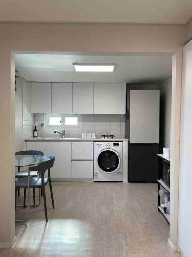 a kitchen with a washing machine and a table in it at ArinHouse in Seoul