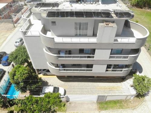 una vista aérea de un edificio de apartamentos blanco con piscina en Residencial Tia Dilma en Bombinhas