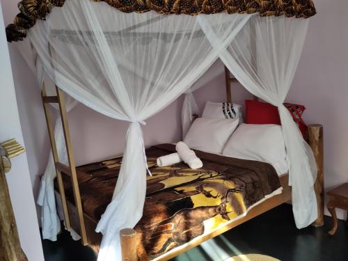 a bedroom with a canopy bed with white curtains at Kilimanjaro Scenic Homestay in Moshi