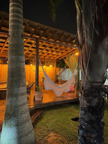 a hammock on the deck of a house at night at Studios Malakoopa - Praia do Rosa in Praia do Rosa