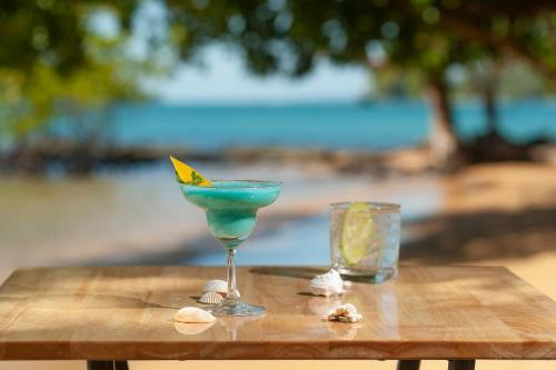 a blue drink in a martini glass on a wooden table at Koh Ta Kiev Island Resort in Koh Ta kiev Island