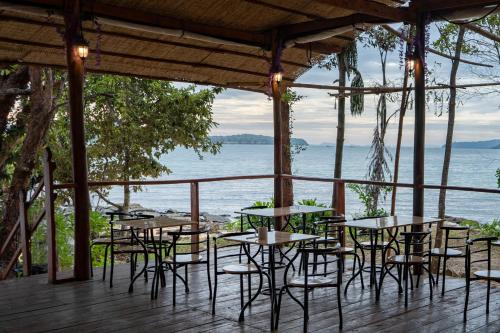 a group of tables and chairs on a deck overlooking the water at Koh Ta Kiev Island Resort in Koh Ta kiev Island