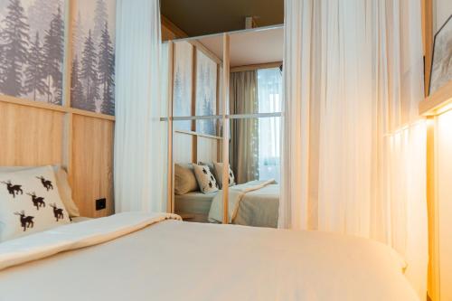 a bedroom with a white bed and a mirror at Winter Park Idila in Bjelašnica
