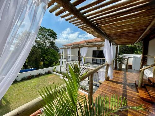 a wooden deck with a pergola on a house at Santomar Guest House in Ilhabela