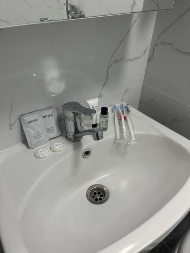 a white sink with toothbrushes on it in a bathroom at Отличная квартира со всеми удобствами. in Almaty