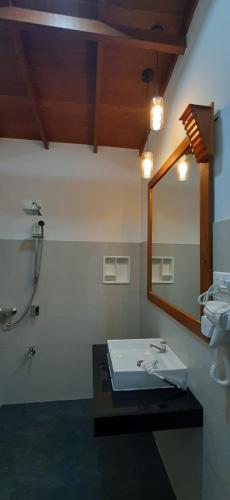 a bathroom with a sink and a mirror at The Otunna Guest House Sigiriya in Sigiriya