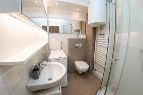 ein kleines Bad mit einem Waschbecken und einem WC in der Unterkunft KAN Suites in Belgrad