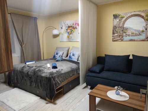 a small bedroom with a bed and a couch at Veludo Apartments Centrum free parking in Banská Bystrica