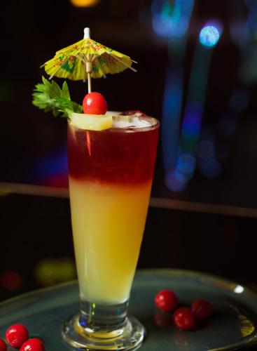 a drink sitting on a table with an umbrella at Hotel Majestic in Kolkata