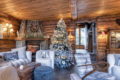 a christmas tree in a living room with a fireplace at Chalet BRAGARD in Limone Piemonte