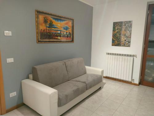 sala de estar con sofá y una foto en la pared en House IL CORALLO, en Castrezatto