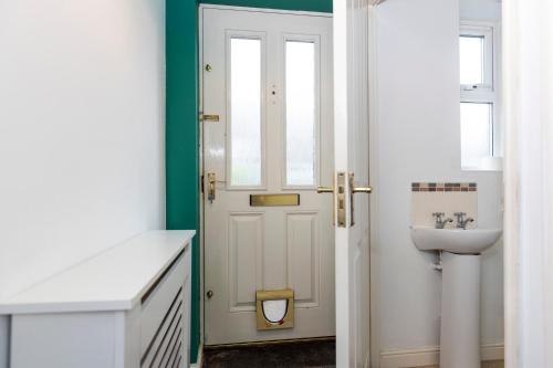 baño con puerta blanca y lavamanos en Ushaw House en Durham