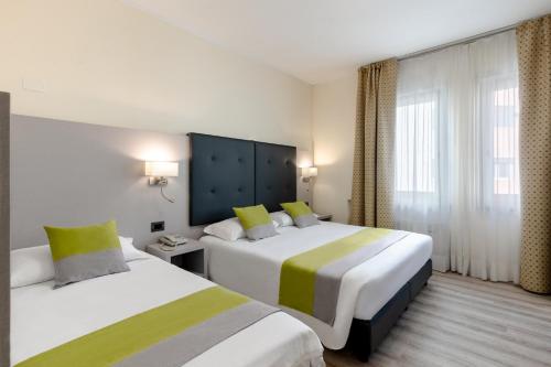 a hotel room with two beds and a window at Hotel Aurora in Mestre