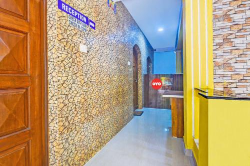 a hallway with a stone wall with a stop sign at OYO Flagship Peppy Guest House in Calangute