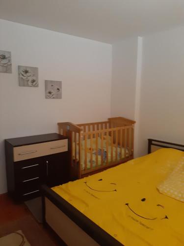 a bedroom with a yellow bed with a smiley face drawn on it at Apartman Vule in Pale