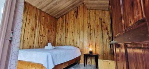 a bedroom with a bed in a wooden wall at Mora's Place B&B in Monteverde Costa Rica