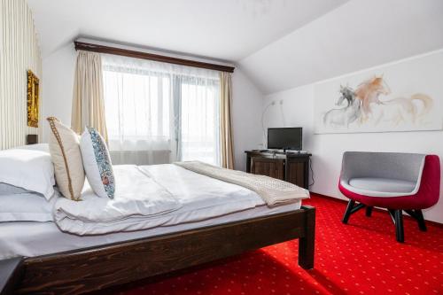 a bedroom with a bed and a chair and a window at VILA LUCA-Hotel in Şirnea