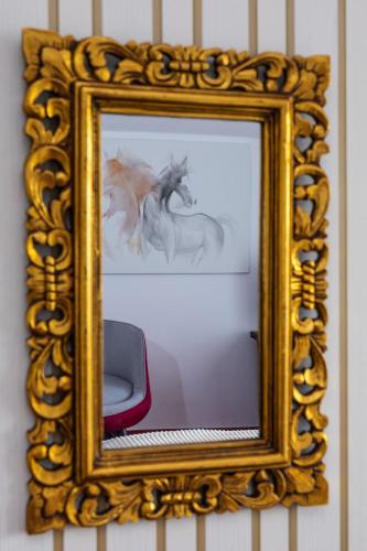 a mirror with a picture of two horses on it at VILA LUCA-Hotel in Şirnea