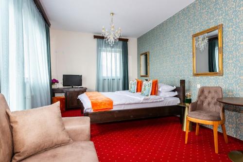 a bedroom with a bed and a table and chairs at VILA LUCA-Hotel in Şirnea