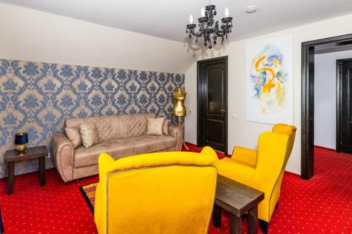 a living room with a couch and yellow chairs at VILA LUCA-Hotel in Şirnea