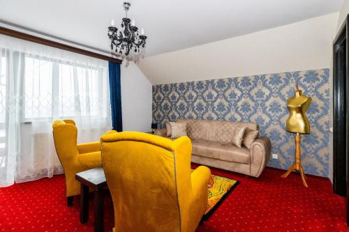 a living room with yellow chairs and a couch at VILA LUCA-Hotel in Şirnea