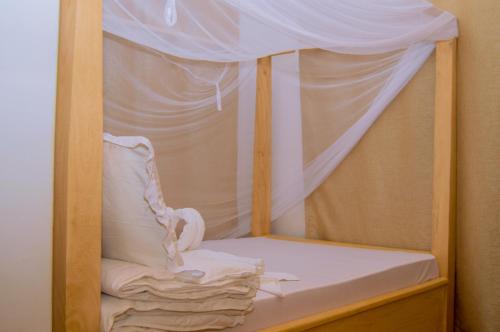 drewniane łóżko piętrowe z białą pościelą i baldachimem w obiekcie Golden hour tiny house w mieście Arusza