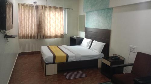 a hotel room with a bed and a chair at Hotel Imperial Inn in Ajmer