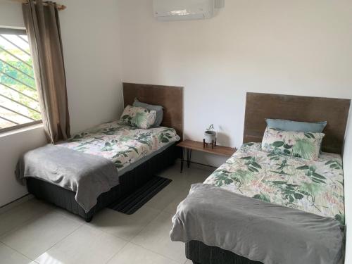1 dormitorio con 2 camas y ventana en F2 Farmhouse, en Omuthiya