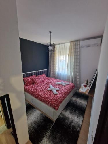 a bedroom with a red bed with two white objects on it at YourHome in Korçë