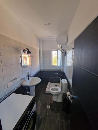 a small bathroom with a toilet and a sink at YourHome in Korçë