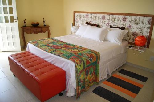 - une chambre avec un grand lit et un pouf rouge dans l'établissement Hotel I 7, à Parnamirim
