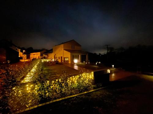 a garden with lights in front of a house at night at Scheier (Ferienwohnungen) in Perl