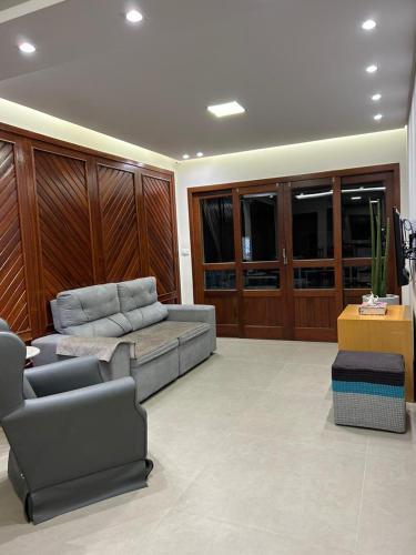 a large living room with a couch and chairs at Apto 302 Edifício Manoel Teixeira in Arroio do Silva
