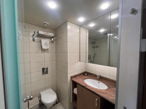 a bathroom with a sink and a toilet and a mirror at Kevens Single Room with Gym and Bar in Jounieh