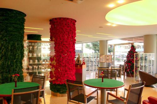 a room with two tables with red flowers and christmas trees at Kevens Single Room with Gym and Bar in Jounieh