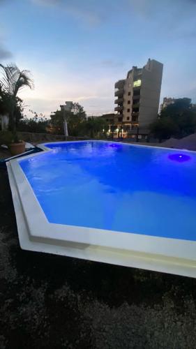 a large blue swimming pool with a building in the background at HOSTEL FAMILIA ZANATTA in Caxias do Sul
