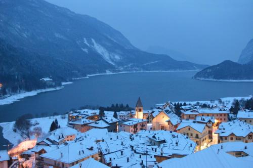 a town covered in snow next to a lake at Hotel Fontanella in Molveno