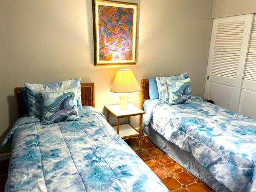 a bedroom with two beds and a table with a lamp at Beach Villa 215 in Humacao