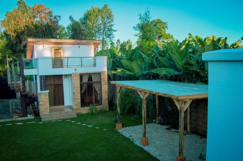 una piccola casa con balcone in un cortile di Golden hour tiny house ad Arusha