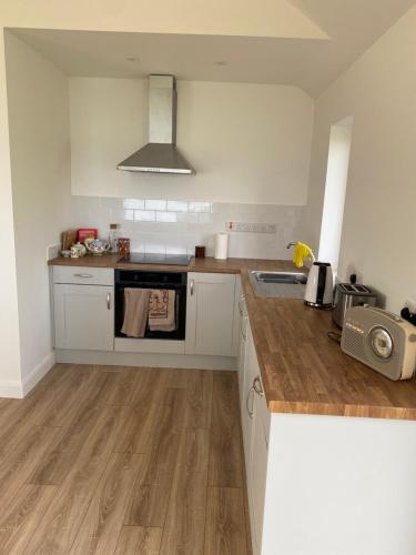 eine Küche mit Spüle und Herd oberen Backofen in der Unterkunft Curlew Cottage in Beltra