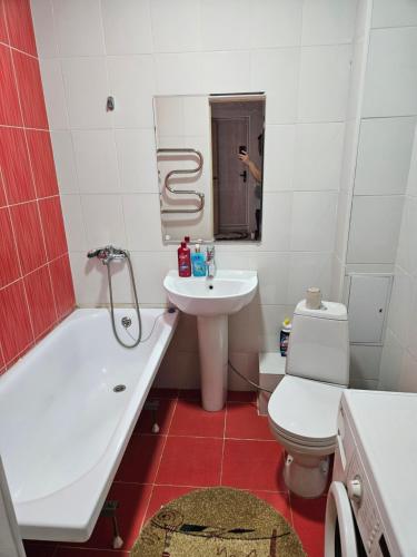 a bathroom with a white tub and a sink and a toilet at 2 комнатная квартира in Aktobe