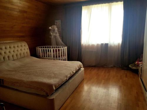 1 dormitorio con 1 cama y una ventana con un vestido en Villa Qeroli Saguramo en Saguramo