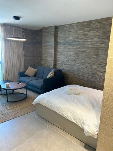 a bedroom with a bed and a blue couch at דירת נופש בהרצליה in Herzliya B