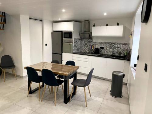 a kitchen with a wooden table and chairs in a room at Maison pour séjour in Mouzay