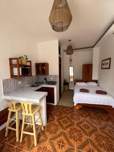 a bedroom with two beds and a kitchen with a table at El Encanto de Mimi in Puerto Ayora