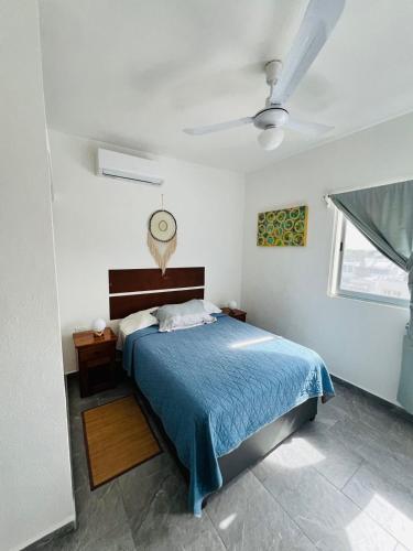 a bedroom with a bed and a ceiling fan at Centrico Departamento 401 in Cancún