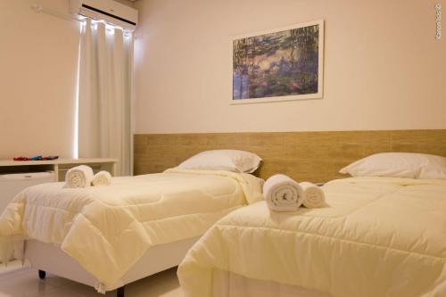um quarto com 2 camas e toalhas em PEDREIRA FLAT HOTEL em Pedreira